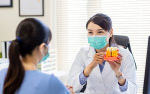 82 Dental - Dentist showing their patient what a dental implant is